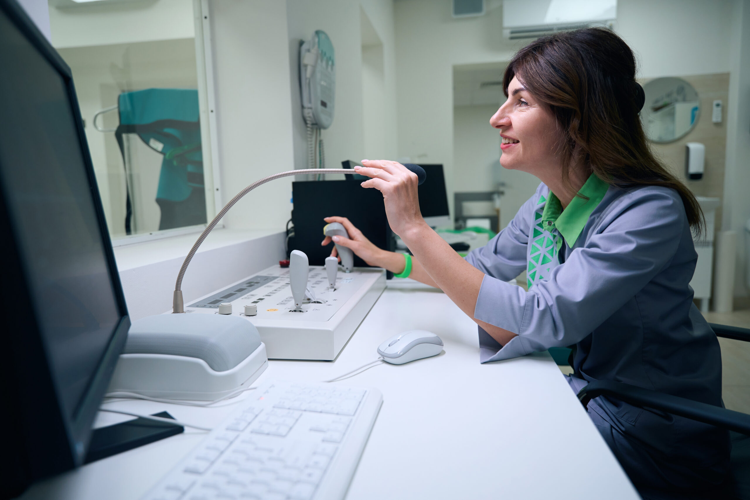 Radiologic technologist communicating with patient during CT scan