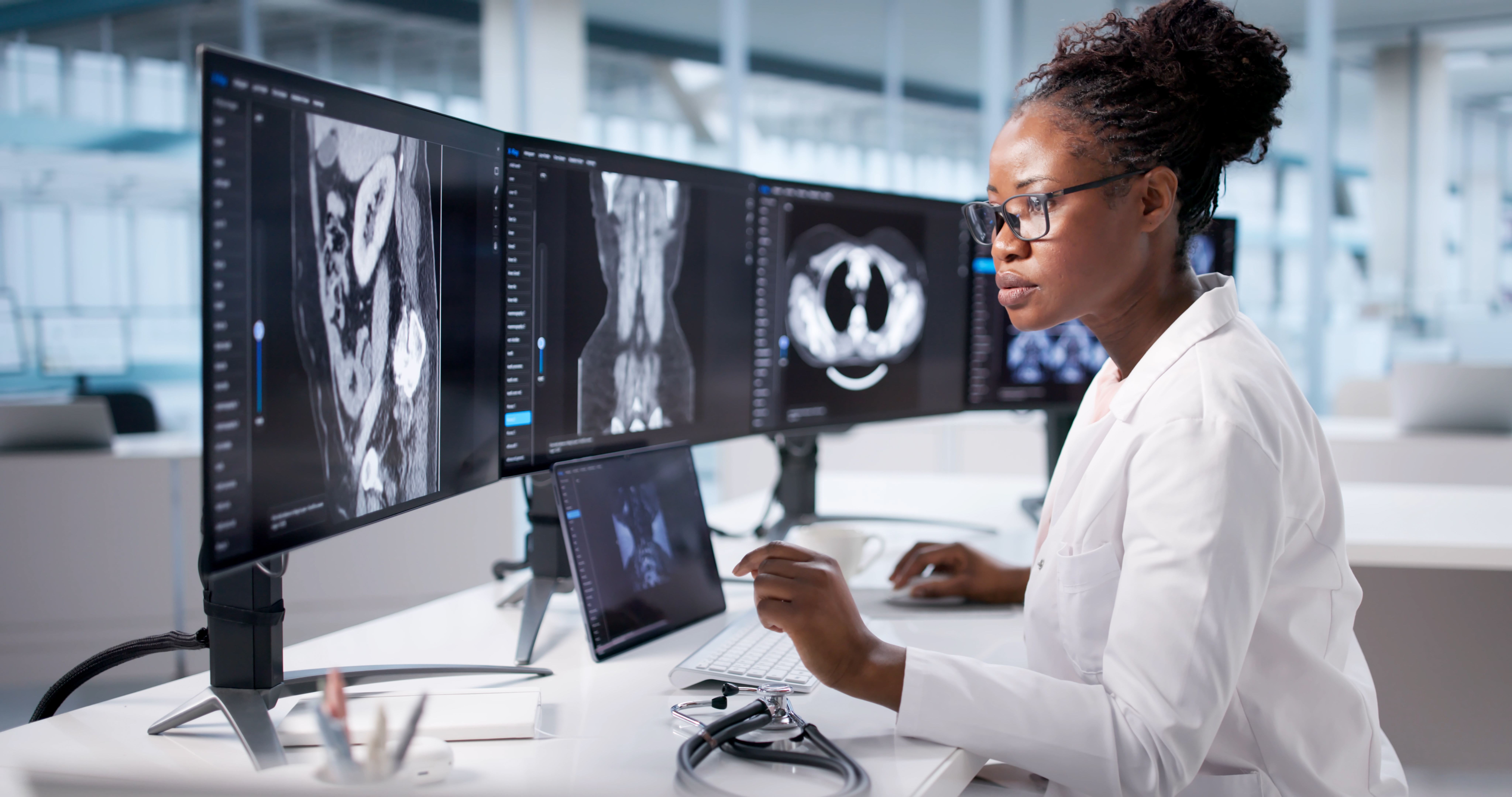 A technician examines a CT scan of a patient's abdomen