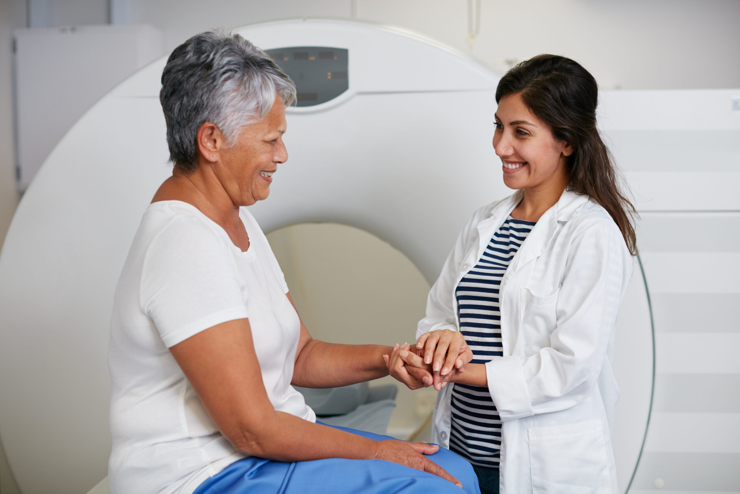 An adult woman speaks to her technologist in preparation for a low-dose CT scan. 